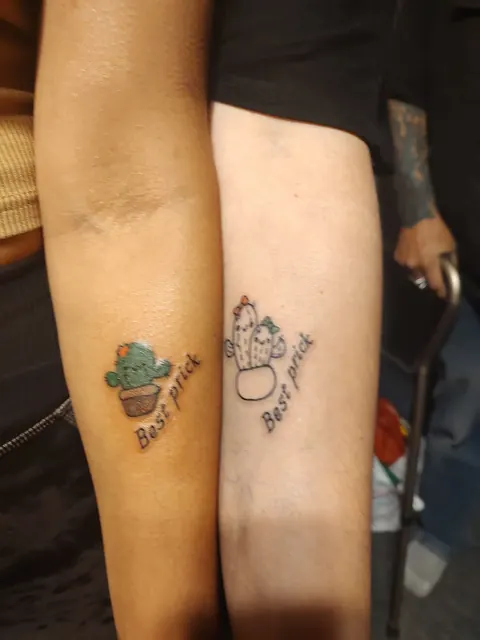 Two matching small cactus tattoos on two forearms with the words Best friend