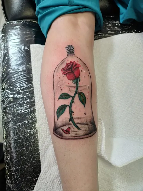 Red rose under a glass dome on the forearm, in color