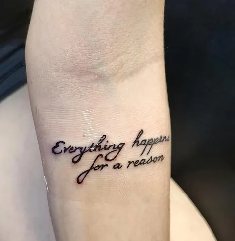 The words Everything happens for a reason in script on the forearm