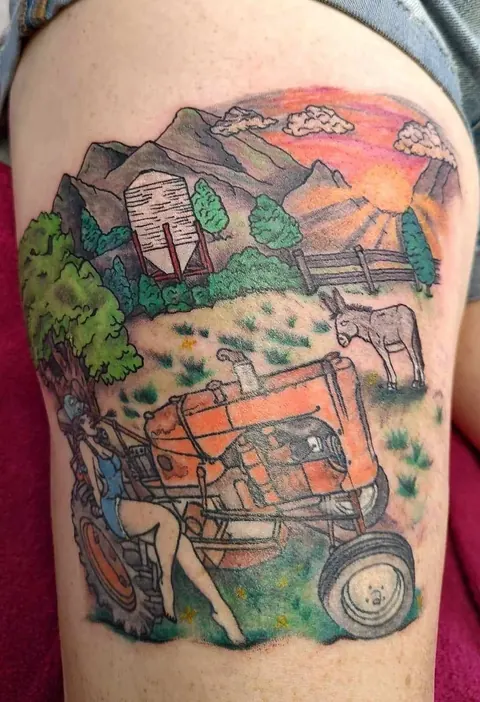 Full color farm scene on the thigh: a red tractor, a pinup, a barn, mountains and a sunset