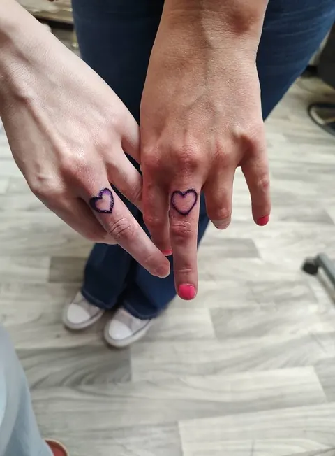 Two small hearts on two people's fingers