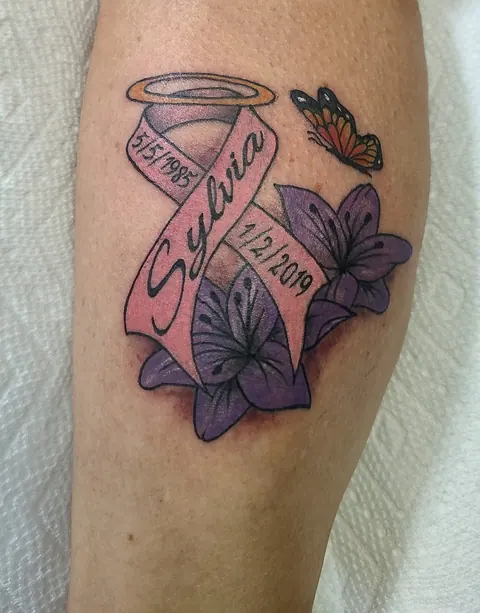 Memorial piece with a halo, a name banner, flowers and a butterfly, in color