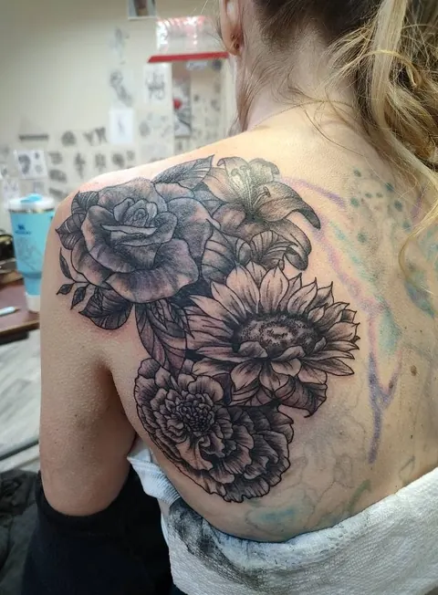 Peonies and roses over the shoulder blade, black and gray