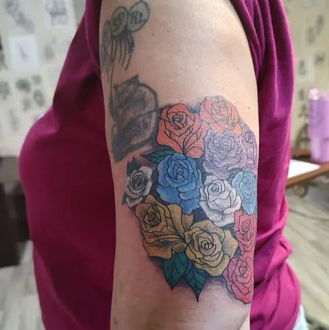 A bouquet of roses in pink, blue, yellow and red on the upper arm