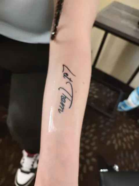 Two words in fine script on the inner forearm