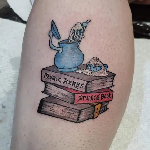 Stack of spellbooks with a pitcher on top on the calf, in color